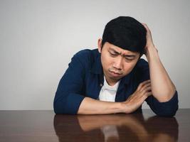 Depressed man sit at table feels sadness about life photo