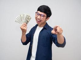 Cheerful man holding a lot of money gesture point finger for choose you isolated photo