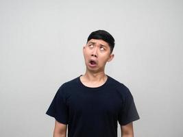 Young asian man feels confused looking up isolated photo