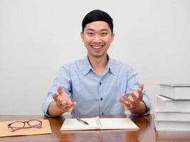 Positive asian businessman sit at workplace table happy smile at camera photo