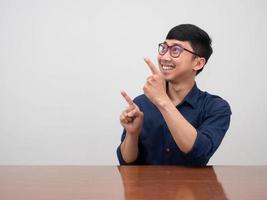 Positive asian businessman wear glasses smile and gesture point finger photo