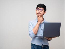 un hombre de negocios asiático tiene un gesto de laptop que duda en pensar en trabajar foto