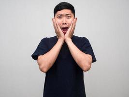 Asian man black shirt gesture surprised shocked at his face isolated photo