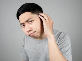 Close up asian man find grey hair on his head feels worried isolated photo