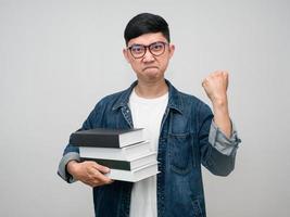 Asian businessman wear glasses jeans shirt hold the book show fist up confident face feels success isolated photo