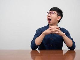 Positive asian businessman wear glasses gesture shocked looking at copy space photo