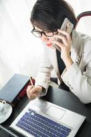 Young woman in smart casual wear working on laptop photo