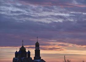 Orthodox church on the background of a beautiful red sunset. Landscape of a Christian church in the evening. photo