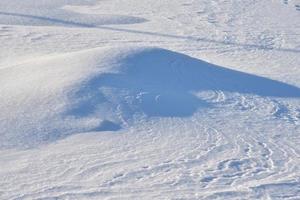 Snowy surface. White snow and snowdrifts in winter. photo