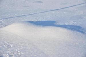 Snowy surface. White snow and snowdrifts in winter. photo