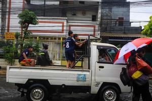 Semarang, December 2022. Some people are walking through the flood that hit the Poncol train station area and some residents are preparing to evacuate. vehicles hit the flood photo