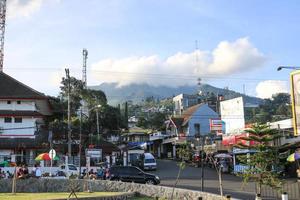 el ambiente de la bulliciosa plaza bandungan semarang con una vista nublada de la montaña al fondo foto