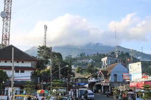The atmosphere of the bustling Bandungan Semarang square with a cloudy mountain view in the background photo