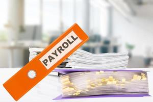 PAYROLL. Business office with office folders and stacks of papers on the desk. photo