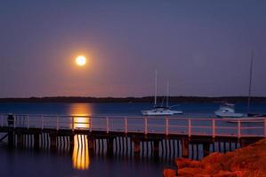 long exposure moon over jetty photo
