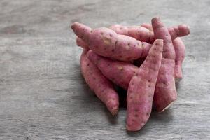 Pile of Yam or Sweet potato on wooden table background. photo