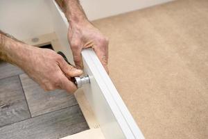 Workers assembling furniture at home. Hands tightening the bolt. photo