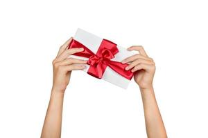 Gift with a bright red ribbon and a bow in the hands of a girl isolated on a white background. photo