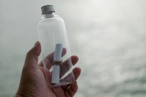 botella de vidrio con un mensaje de papel. llorando por ayuda. salvar nuestras almas foto