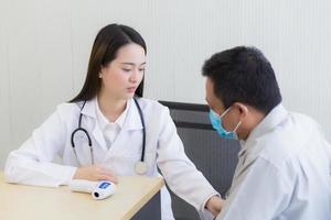 Hermosa joven asiática doctora hablando con un paciente hombre