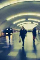 Lens blur image of a subway with silhouettes of moving people. photo