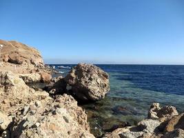 Scenic view of red sea against sky and mountains photo