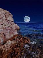 Scenic view of red sea at night with full moon above the sea and mountains photo