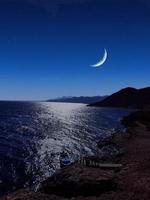 Scenic view of red sea at night with full moon above the sea and mountains photo