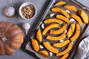 Ripe musk gourd and sliced gourd pieces on a baking sheet photo