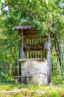 Old well with iron bucket on long forged chain for clean drinking water photo