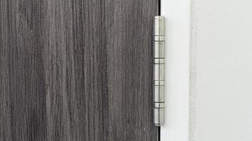 Hinge of door stainless steel door knob Installed on gray door floor with wood pattern. photo