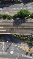 imagens aéreas de trilhos de trem passando pela cidade de luton, na inglaterra. videoclipe vertical e estilo retrato foi capturado com a câmera do drone video
