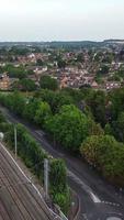 imagens aéreas de trilhos de trem passando pela cidade de luton, na inglaterra. videoclipe vertical e estilo retrato foi capturado com a câmera do drone video