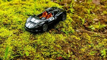 Minahasa, Indonesia  saturday, 10 December 2022, a toy car on green mossy ground photo