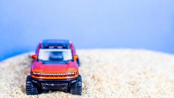 Minahasa, Indonesia  Monday, 12 December 2022, toy car on the sand on a blue background photo