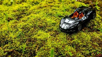 Minahasa, Indonesia  saturday, 10 December 2022, a toy car on green mossy ground photo