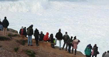 nazare, portugal, 2020 - foule regardant les vagues intenses éclaboussant dans la mer à nazare, portugal pendant une tempête de mer au ralenti - prise de vue en grand angle video