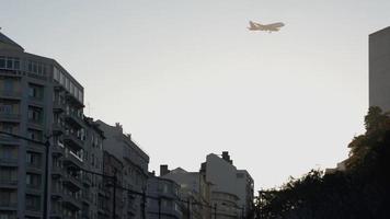 un avión volando alto en el cielo sobre los edificios en la rotonda marques de pombal en lisboa, portugal - tiro de ángulo bajo