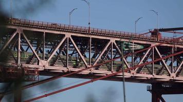 le magnifique pont suspendu abril au portugal avec un train de voyageurs passant sous la route - gros plan video