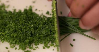 Chopping Fresh Chives On The Chopping Board For Sushi Preparation - close up, slow motion video
