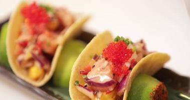 Sushi tacos - capocuoco guarnire il tacos con tritato cipolla erba cipollina. - vicino su tiro video