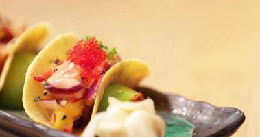 Küchenchef legt Wasabi vor dem Servieren auf die Seite von Sushi-Tacos. - Nahaufnahme