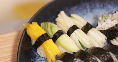 plato de rollos de sushi y sushi nigiri servido en un restaurante japonés. - panorámica de cerca video