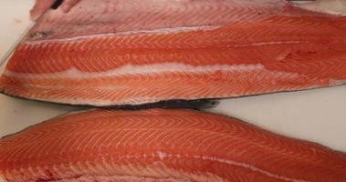 Knife Scraping On Top Of Salmon Meat In A White Table. - Close Up-Topdown Shot video