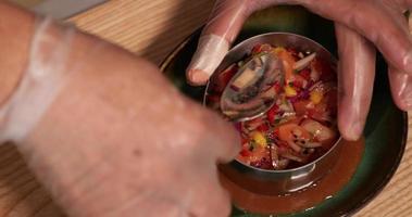 chef pressionando o ceviche de atum dentro do molde com uma colher. - tiro de alto ângulo video