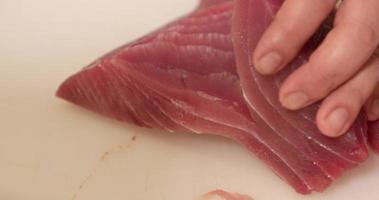cuchillo afilado usado para cortar carne cruda de atún fresco para preparar sushi en un restaurante japonés - primer plano, cámara lenta video