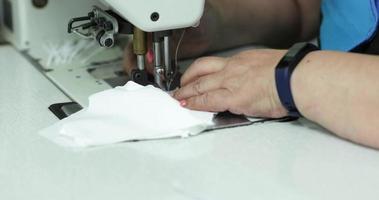 Seamstress Hand Carefully Sewing A White Cloth Filter For Face Masks - Covid-19 Pandemic - Pan Right Shot Slow Motion video