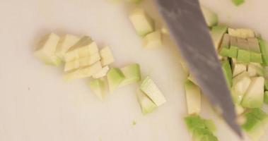 chef coupant l'avocat en petits morceaux pour le plat de sushi. - prise de vue en plongée video