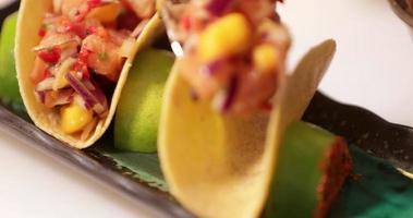 capocuoco mettendo condito otturazioni su il croccante taco conchiglia - Sushi tacos. - vicino su tiro video