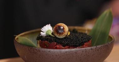 tonno tartare con nero capriolo caviale e fresco fiori su superiore come contorno. - vicino su tiro video